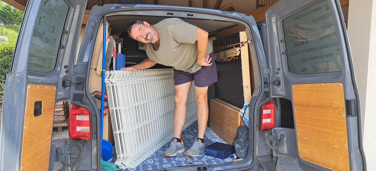 Olivier VERGÉ chargeant un portail dans le camion atelier d'Olivier Services