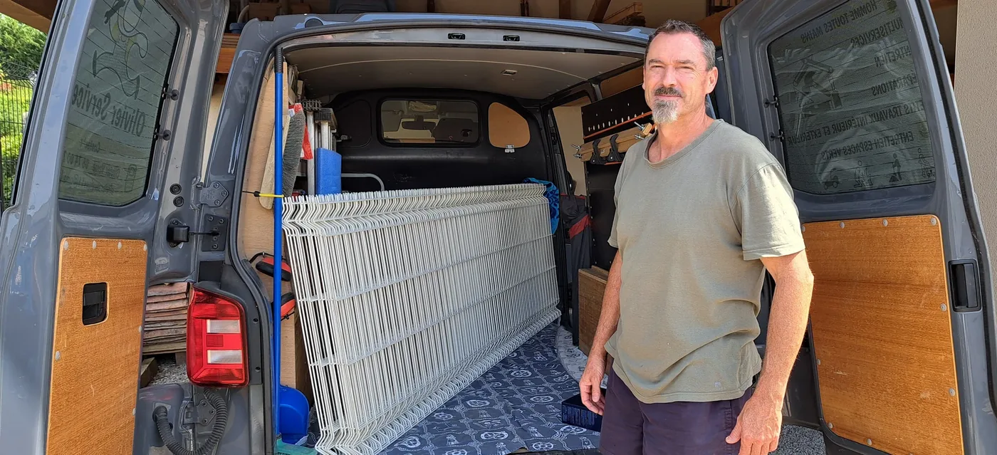Olivier VERGÉ devant son camion atelier chargé de panneaux de clôture
