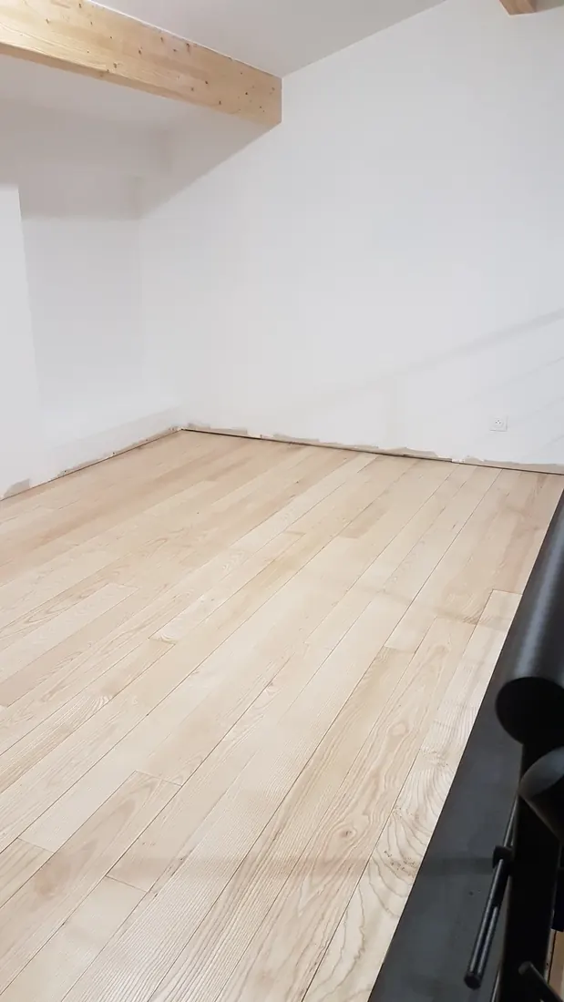 Parquet terminé avec plinthes ajustées sous rampant